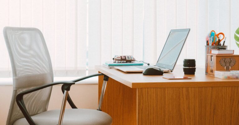 A tranquil modern home office featuring a wooden desk, ergonomic chair, and soft natural light.