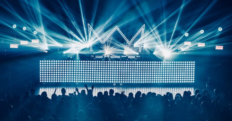 An electrifying concert atmosphere featuring dynamic laser lights and a vibrant crowd enjoying live music.