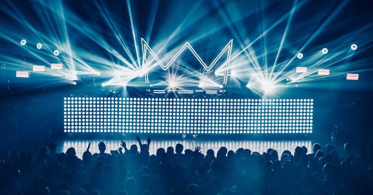 An electrifying concert atmosphere featuring dynamic laser lights and a vibrant crowd enjoying live music.