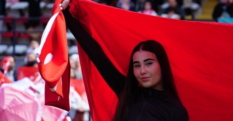 A young woman proudly waves the Turkish flag during a national celebration in Istanbul.