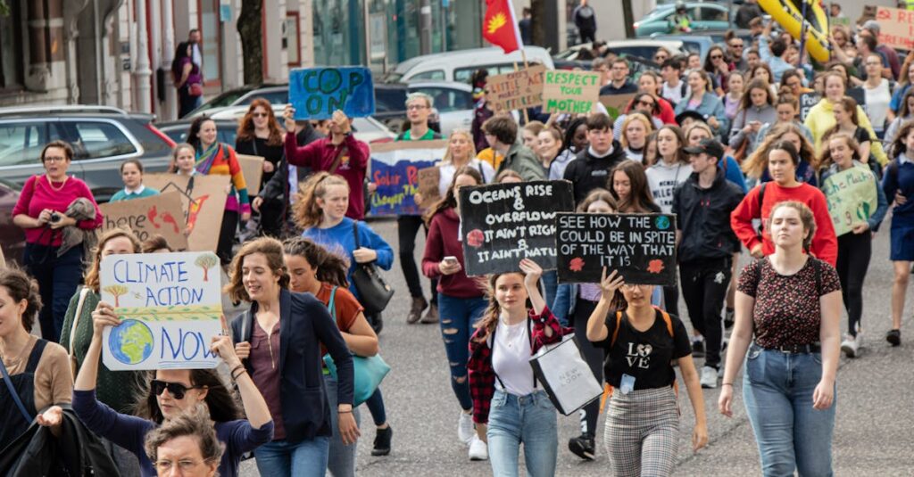 A vibrant climate march with diverse group holding signs demanding climate action.