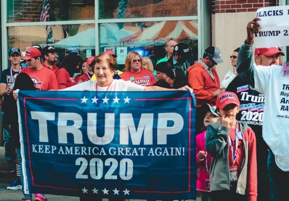 A crowded political rally in Wheeling, showcasing Trump supporters with banners and signs.