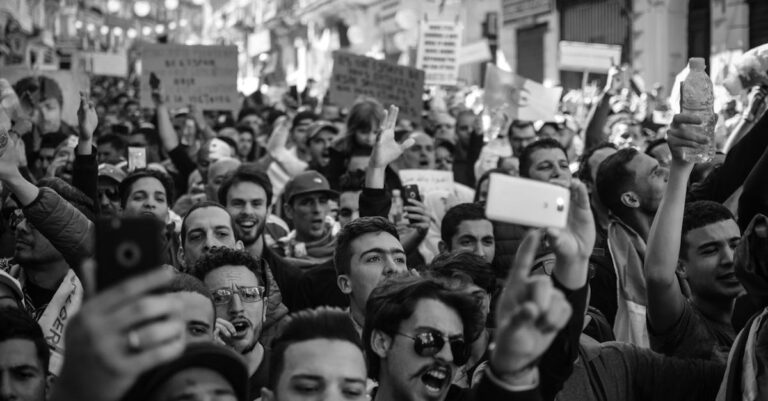 Crowded Algerian street protest captured with intensity and detail.