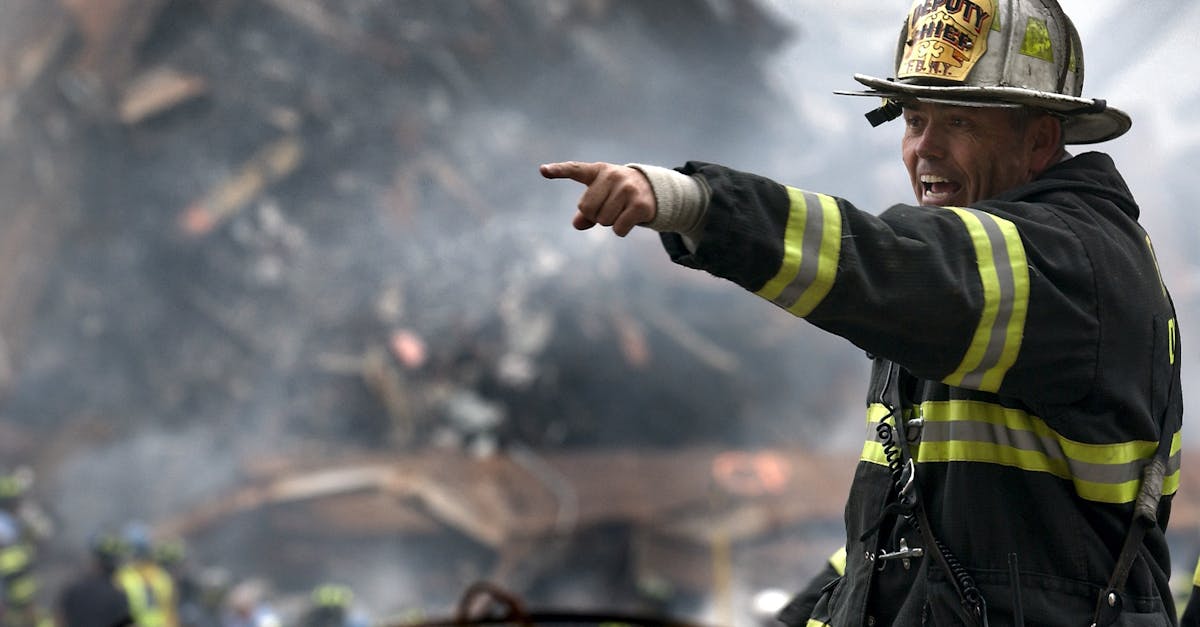 A firefighter in action at a disaster scene, directing rescue operations amidst smoke and debris.