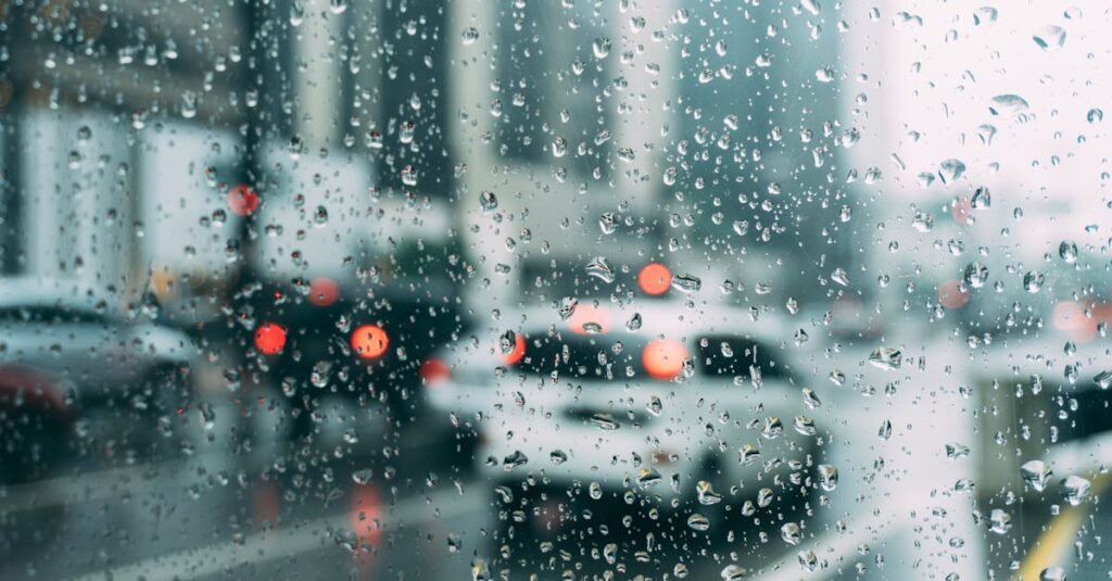 Blurred city traffic seen through a window with raindrops, a perfect rainy day scene.