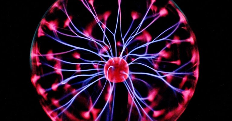 Close-up of a plasma globe with vibrant neon sparks against a dark background.
