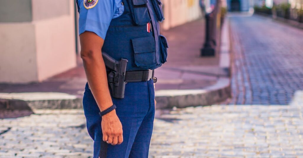 Uniformed police officer stands on a cobblestone street, ensuring public safety.