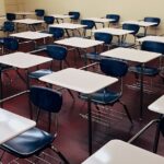 An indoor view of a modern, clean classroom with rows of empty desks and chairs.