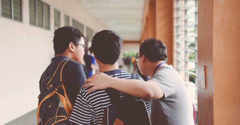Group of male teenagers walking in a school corridor with backpacks, bonding and chatting.