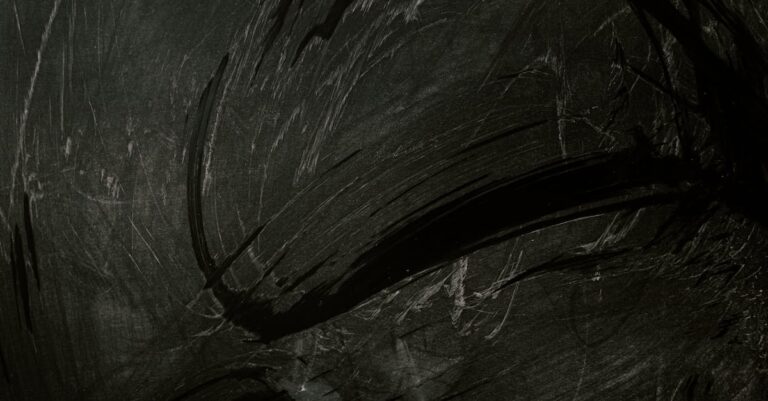 Intriguing black chalkboard with expressive chalk smudges, ideal for backgrounds or textures.