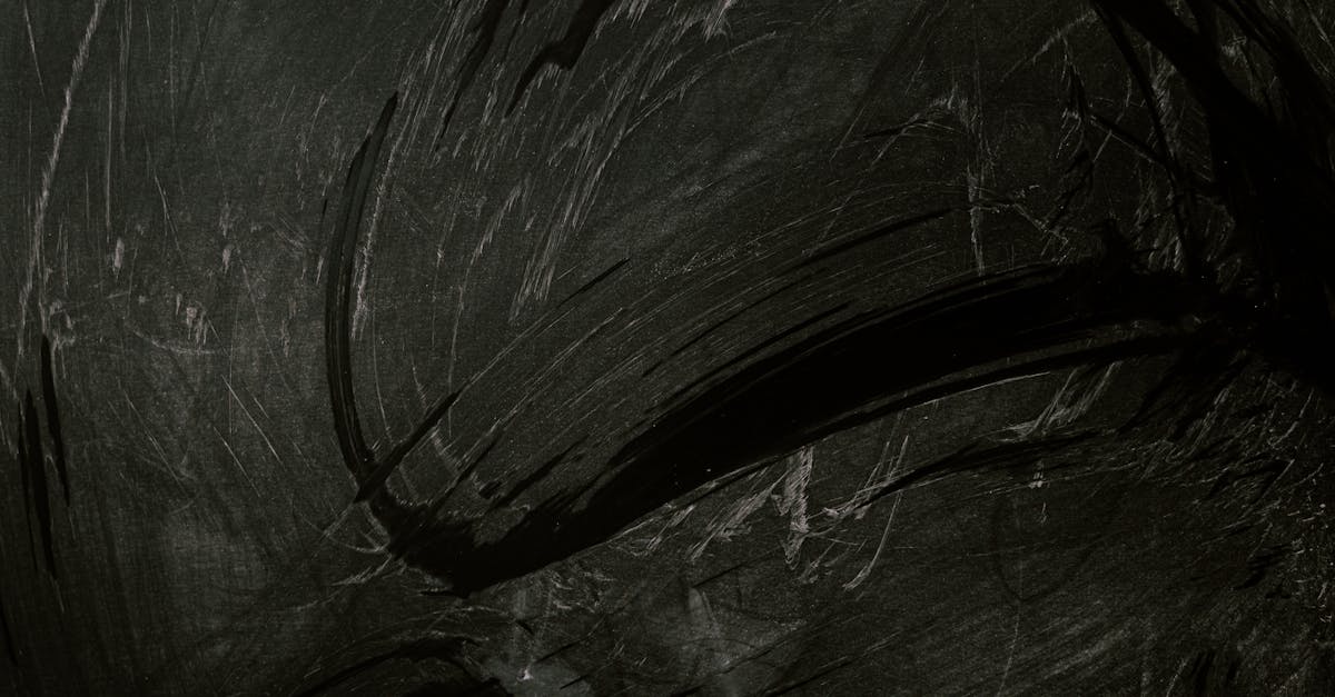 Intriguing black chalkboard with expressive chalk smudges, ideal for backgrounds or textures.