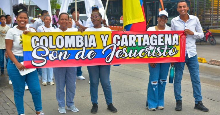 Group of people holding a 'Colombia y Cartagena' banner in a street parade.