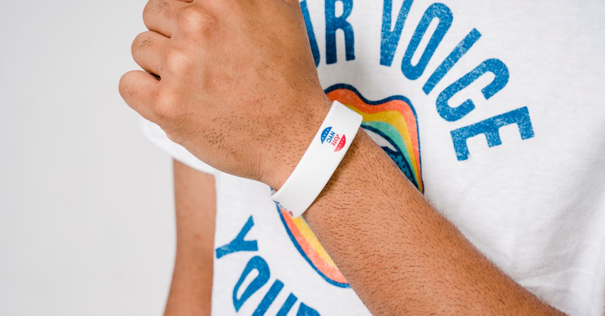 Person wearing a white 'I Voted' wristband and a shirt with 'Your Voice' text.