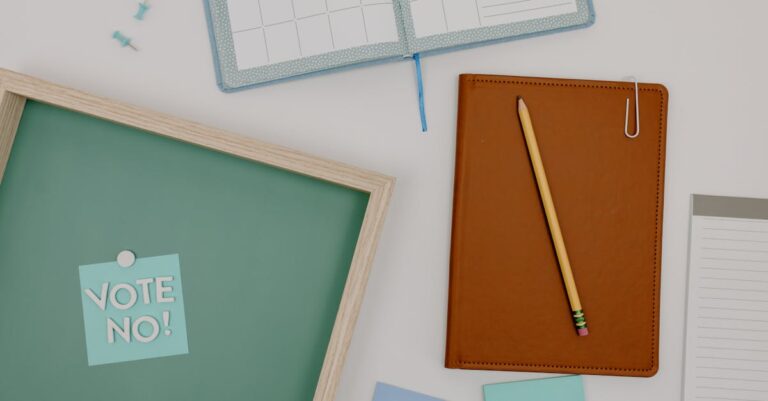 Top view of office supplies including a planner, pencil, and vote message for creative workspaces.