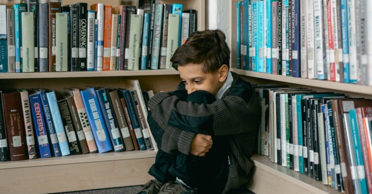 Young boy in library appears sad, sitting alone among bookshelves, suggesting themes of solitude and bullying.
