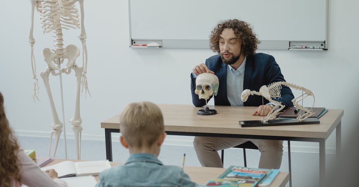Teacher explaining human anatomy with skeleton model to attentive students in a classroom.