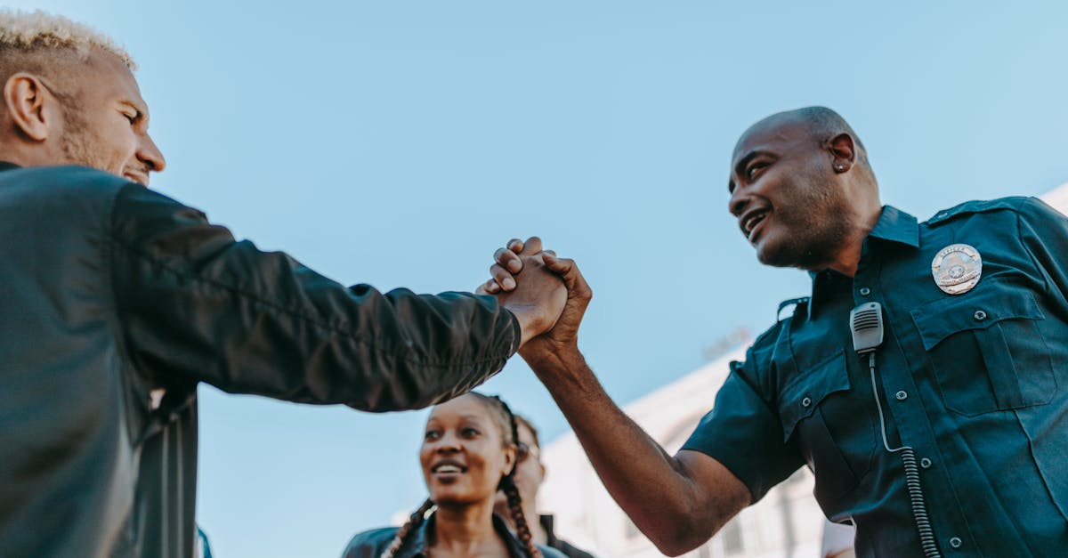A friendly handshake between a police officer and a civilian during an outdoor community event.
