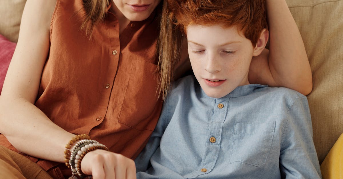 A mother and son bonding as they use a tablet together indoors.