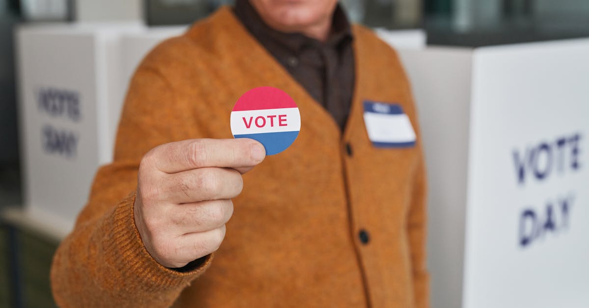 A senior adult holding a vote sticker inside a polling booth during election day.