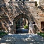 Gothic-style stone archway entrance at Yale University campus, surrounded by greenery.