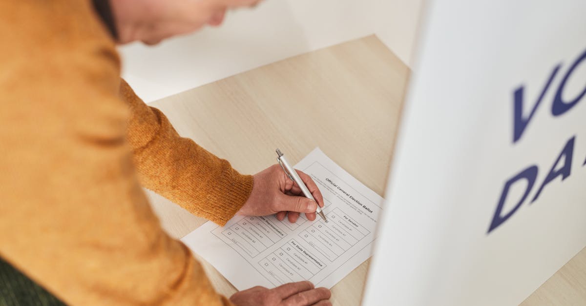 Senior man marking a ballot at a voting booth in an indoor polling station.