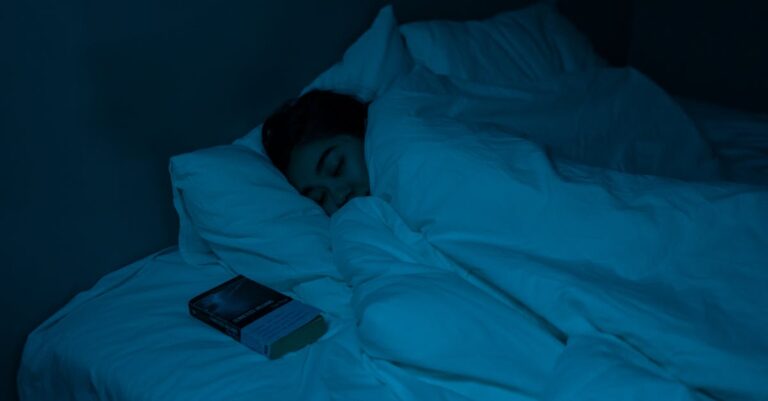 A woman peacefully sleeping with a book under blue night lighting, showcasing a cozy bedtime atmosphere.