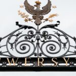Beautifully designed ornate iron gate at a university, featuring an eagle emblem.