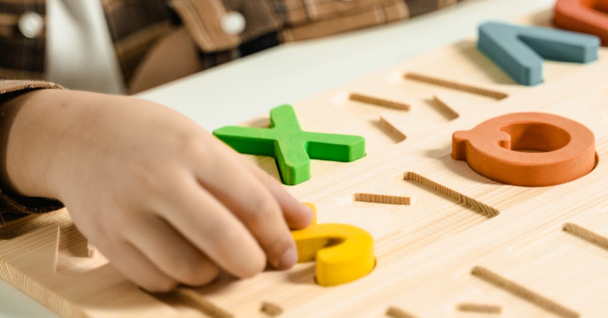 Close-up of a child playing with a colorful alphabet puzzle board.
