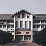 Facade of a university chemistry building framed by trees and a clear sky.