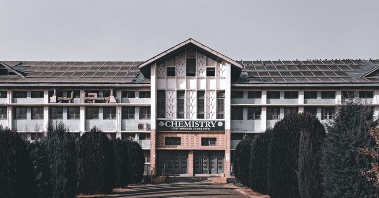 Facade of a university chemistry building framed by trees and a clear sky.