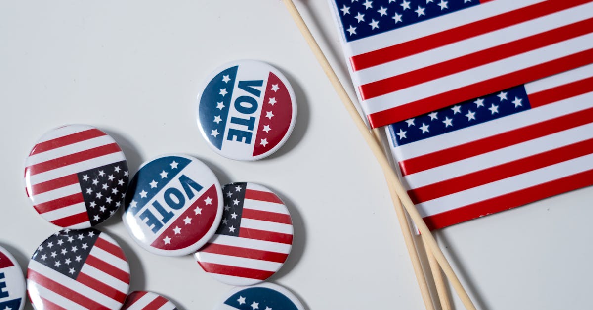 Close-up of American flags and vote buttons on a white backdrop, symbolizing U.S. elections.