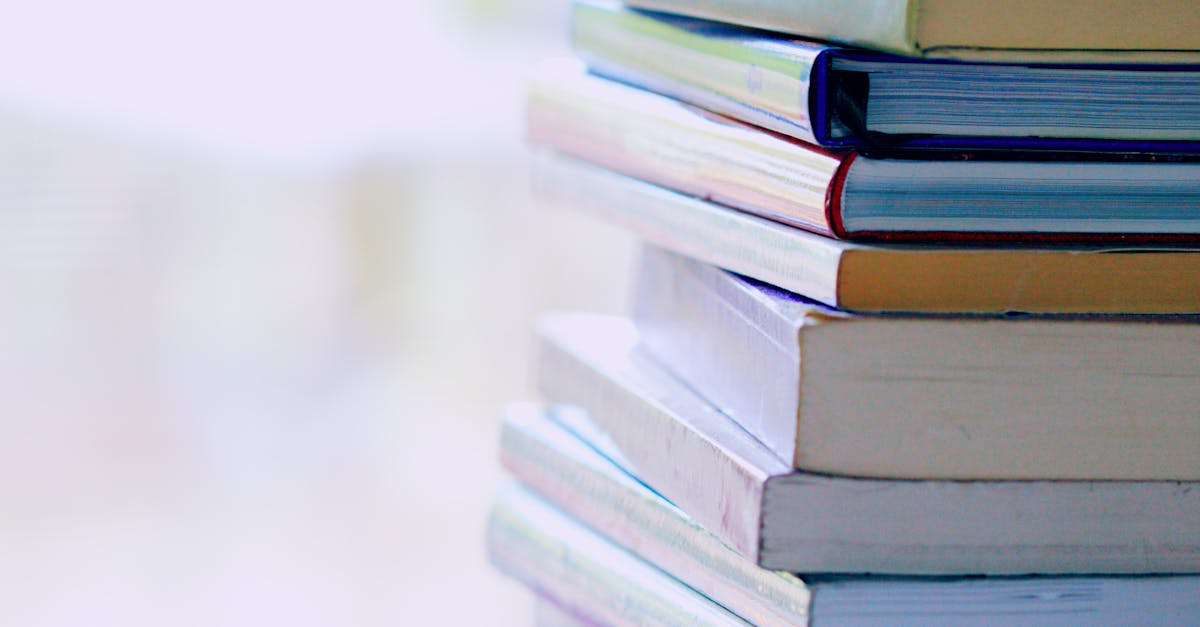 A tall stack of colorful hardcover books on a table indoors, perfect for library-themed concepts.